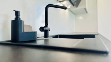 Une cuisine moderne dotée d’une machine à café intégrée et d’un design épuré et minimaliste.