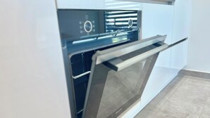 An open modern oven with a digital control panel and a glass door.