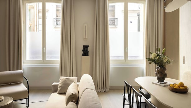 A modern living room with a sofa, a dining table with chairs, and a vase with flowers. - Luxury Flat -2br/8p- Madeleine/saint Honore (Paris)