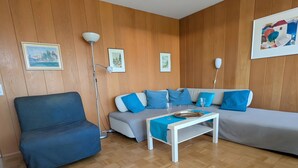 Ein Wohnzimmer mit einer Couch, einem Sessel, einem Couchtisch und einer Stehlampe.