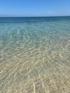 Eau claire et peu profonde, où l’on peut distinguer les motifs formés par le sable.