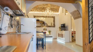 Une cuisine moderne avec un plan de travail en bois, un évier et un lustre. On y trouve également un coin repas avec une table et des chaises.