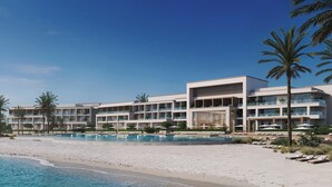 Un hôtel moderne doté de nombreux balcons, d’une piscine et situé en bord de mer.