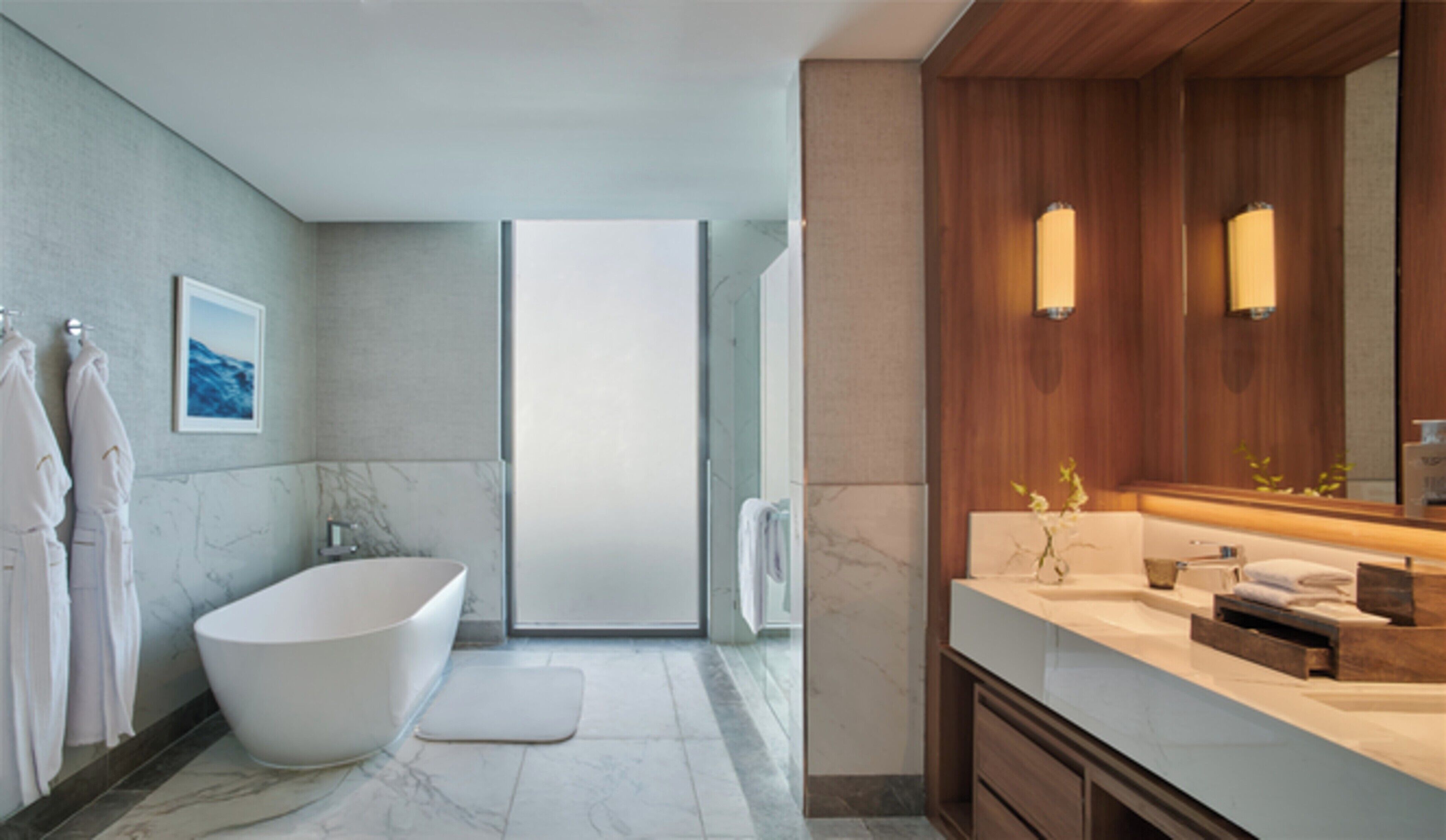 Un baño moderno con una bañera independiente, un espejo grande y una zona de ducha.
