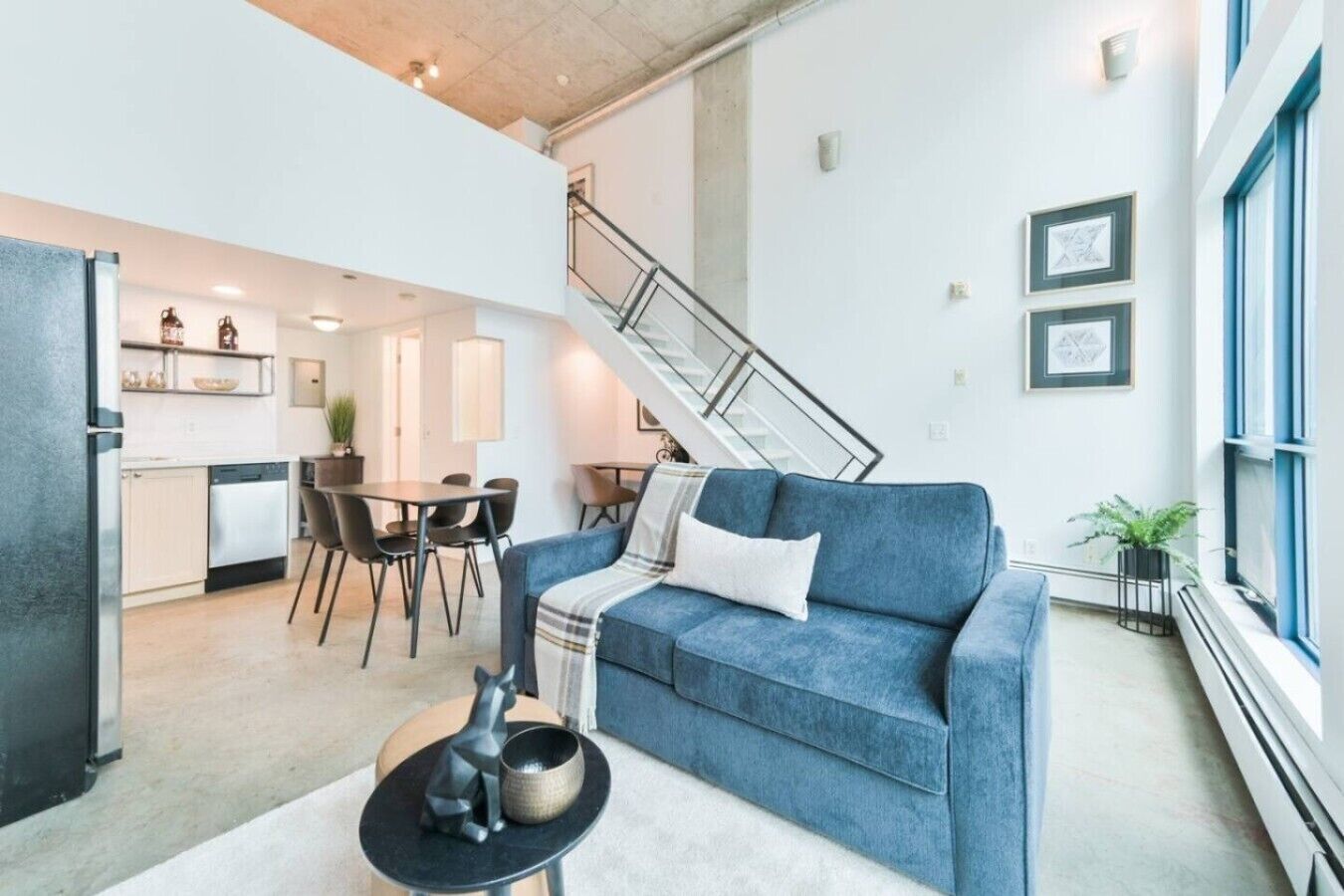 Ein zeitgemäßer Wohnraum mit Küche, Essbereich und einer Treppe.
