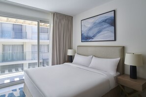 Deluxe One Bedroom Suite Partial Pool View | Safe på rommet, skrivebord, blendingsgardiner og strykejern/-brett