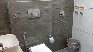A modern bathroom with a toilet, bidet, and sink. - Hotel Kamboj (Kharar)