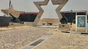 Een ster-vormig monument met kanonnen, een kaartpresentatie en een koepelstructuur.