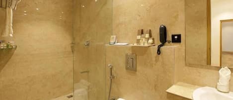 A modern bathroom with a glass-enclosed shower, a toilet, and a sink.