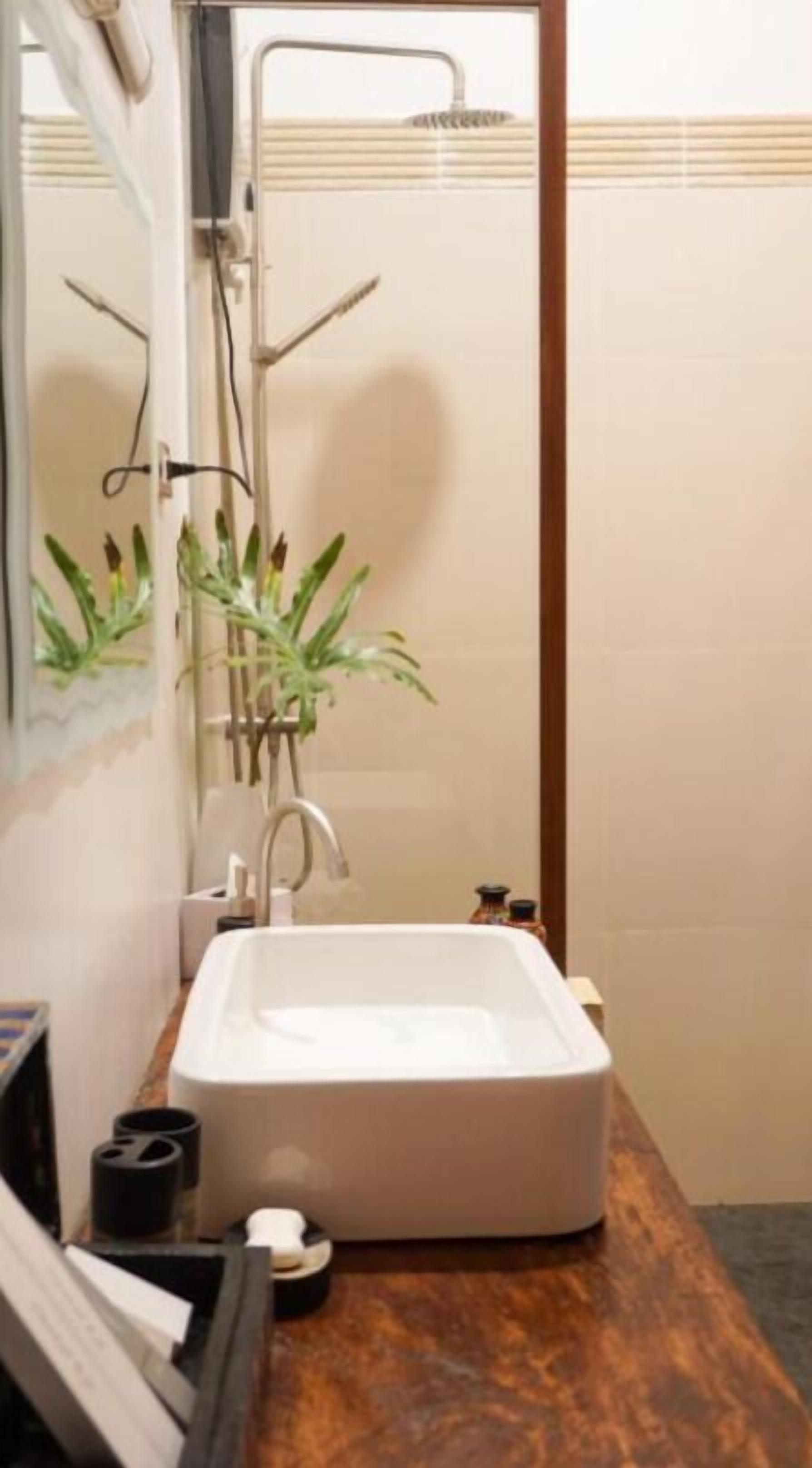 A bathroom with a white sink, a mirror, and a shower.