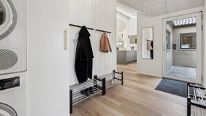 Una cocina moderna con una isla central, un horno empotrado y un colgador para utensilios de cocina.