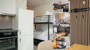 Una camera d'albergo compatta con angolo cottura, un letto a castello, zona pranzo e bagno.