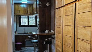A kitchen with wooden cabinets, a window, and a tiled floor. - Apartment Saly 3ch - 3sb - Swimming pool - Beach - Veranda (Saly)