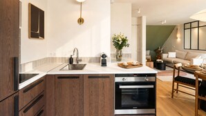 Una cucina moderna con forno integrato, macchina da caffè e lavandino.
