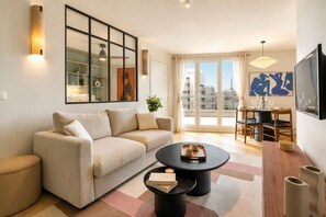 Un salon moderne avec un canapé, une table basse et un coin repas.