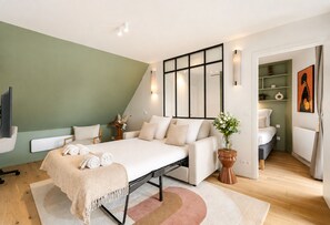 Une chambre à coucher moderne avec un lit, des tables de chevet, un miroir et une vue sur la salle de bain.