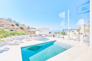 A rooftop pool with lounge chairs, a glass balustrade, and a view of the sea and hills. - Villa 'La Buena Vida Torrox' with Sea View, Wi-Fi and Air Conditioning (Torrox)