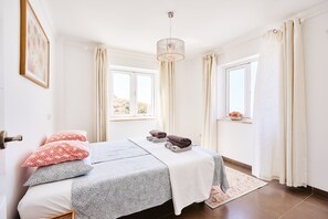 A bedroom with a bed, a window, curtains, a chandelier, and a framed picture on the wall. - Villa 'La Buena Vida Torrox' with Sea View, Wi-Fi and Air Conditioning (Torrox)