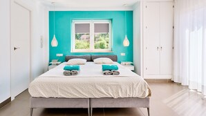 A bedroom with a bed, a window, a wardrobe, and a nightstand.