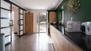 A modern kitchen with a black countertop, wooden cabinets, and a decorative wall piece.