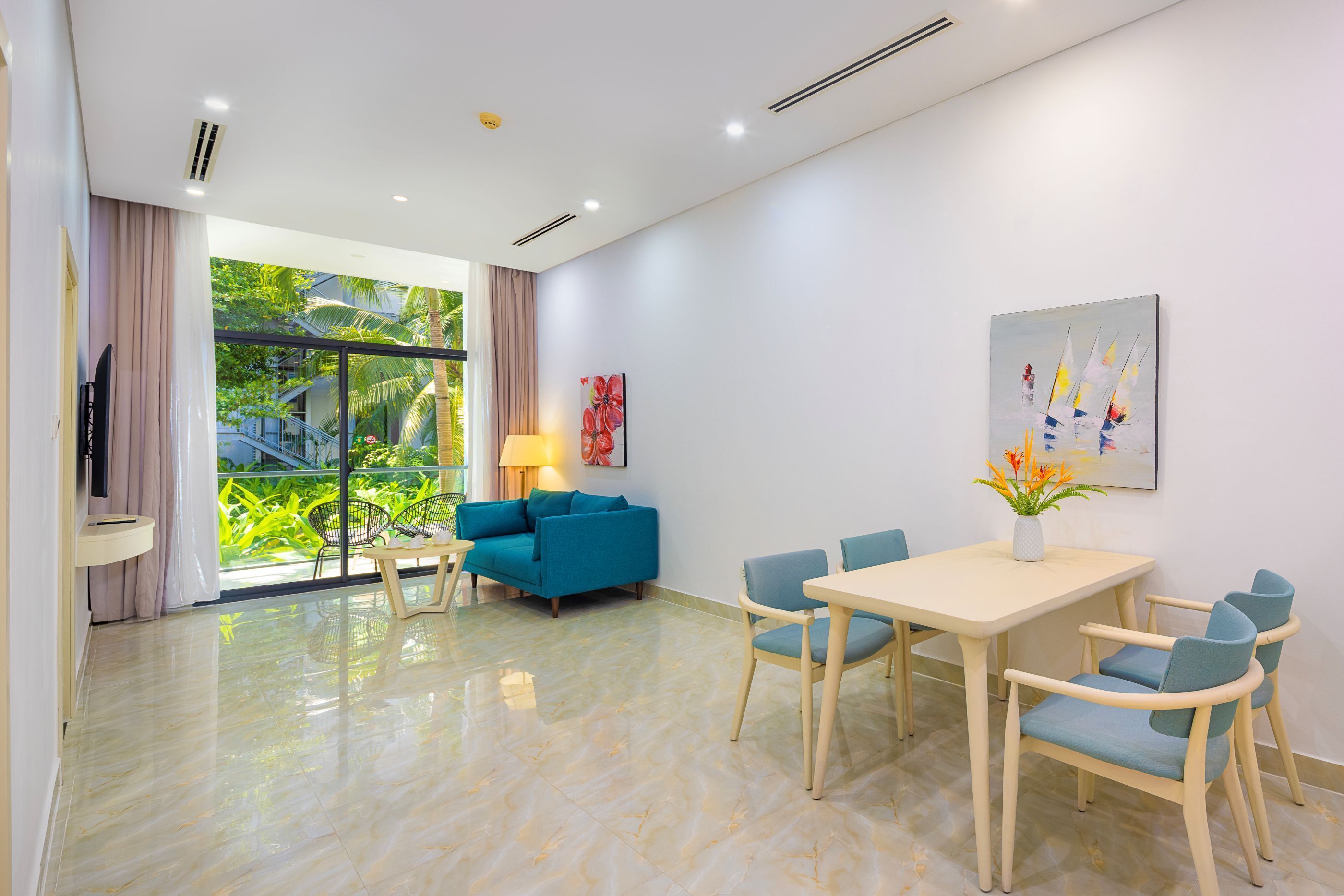 Une chambre d’hôtel moderne dotée d’un balcon, d’un coin repas et d’une télévision.