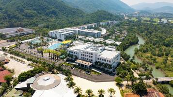 Un resort con varias construcciones, una piscina y un río.