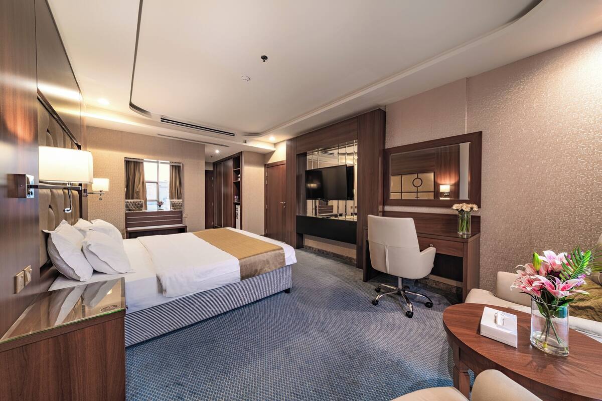 Une chambre d’hôtel équipée d’un lit, d’un bureau, d’une chaise et d’un téléviseur.