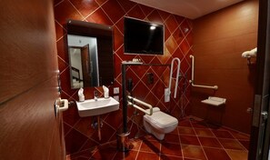 Un baño con lavamanos, inodoro y espejo.