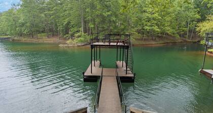 Lakefront 4BR/6BA home with private dock, fire pit, smart TVs in all rooms, sunroom, BBQ grill, and fenced game yard. Includes golf cart, 2 fridges, double oven, and more. 1 mile to Aqualand Marina & Pig Tales Restaurant.