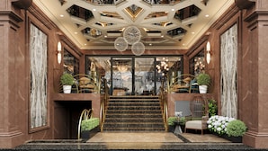 A grand entrance with a marble staircase, a chandelier, and a seating area with plants. - L'Heritage Premium Hanoi Central (Hanoi)
