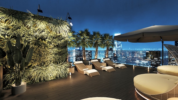 A rooftop lounge with lounge chairs and a view of the city skyline at night. - L'Heritage Premium Hanoi Central (Hanoi)