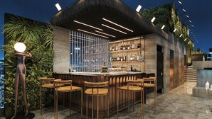 An outdoor bar area with a curved counter, multiple bar stools, and a wall of bottles. - L'Heritage Premium Hanoi Central (Hanoi)