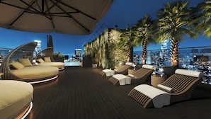 A rooftop lounge with modern seating, a pool, and a city skyline view. - L'Heritage Premium Hanoi Central (Hanoi)