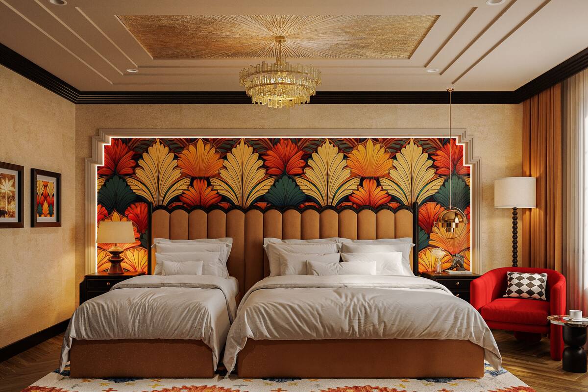 Een hotelkamer met een groot bed, een rode fauteuil, een nachtkastje en een decoratieve wand met bladmotieven.
