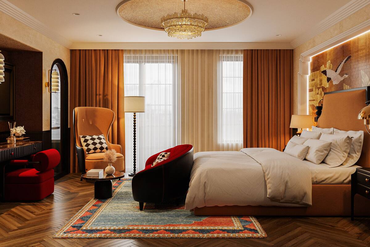 Een ruime slaapkamer met een groot bed, een kroonluchter, een rode fauteuil en een klassieke open haard.
