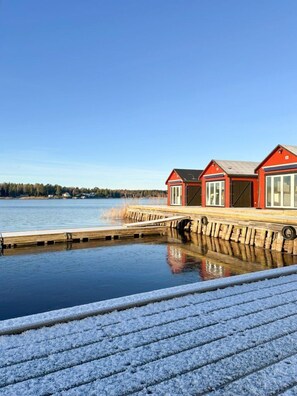A waterfront property with a wooden dock leading to a building with large windows. - First Camp Herrgårdsliv - Kristinehamn (Kristinehamn)