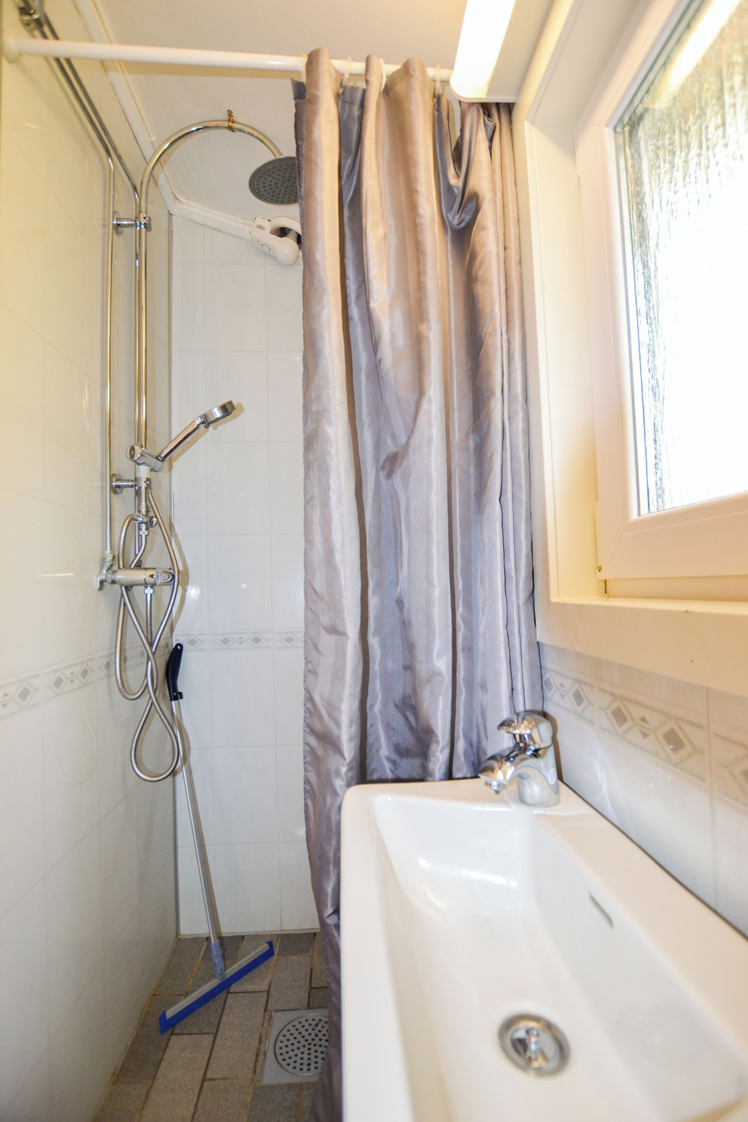 Un baño con ducha, bañera y ventana.