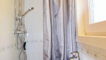 Un baño con ducha, bañera y ventana.