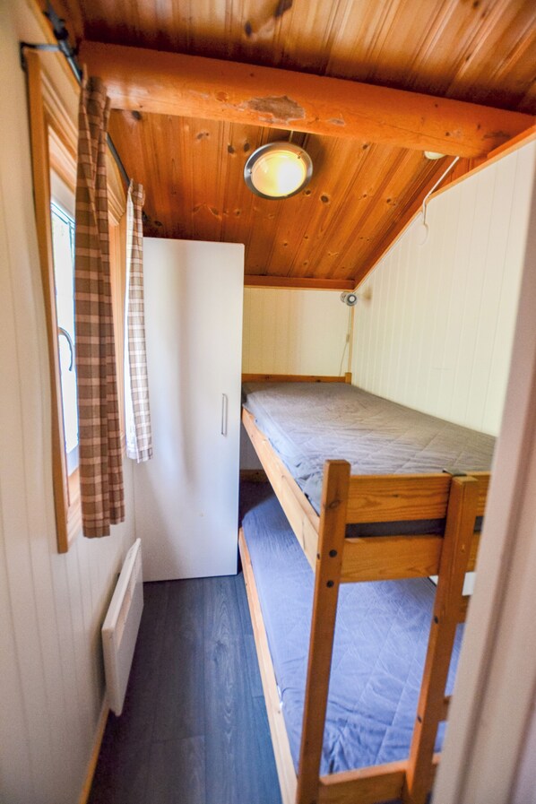 A compact room with a bunk bed, a small white cabinet, and a window with curtains. - First Camp Haganäset - Charlottenberg (Amotfors)