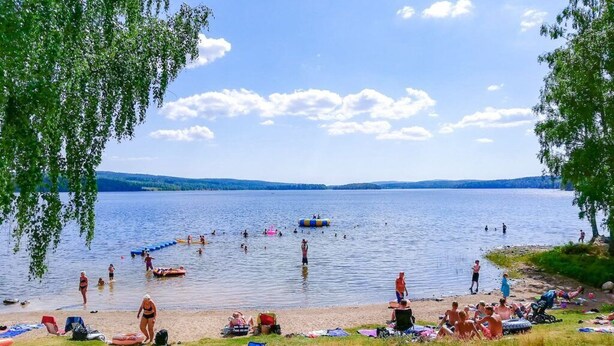 Une plage au bord d’un lac où l’on peut se baigner et prendre des bains de soleil.