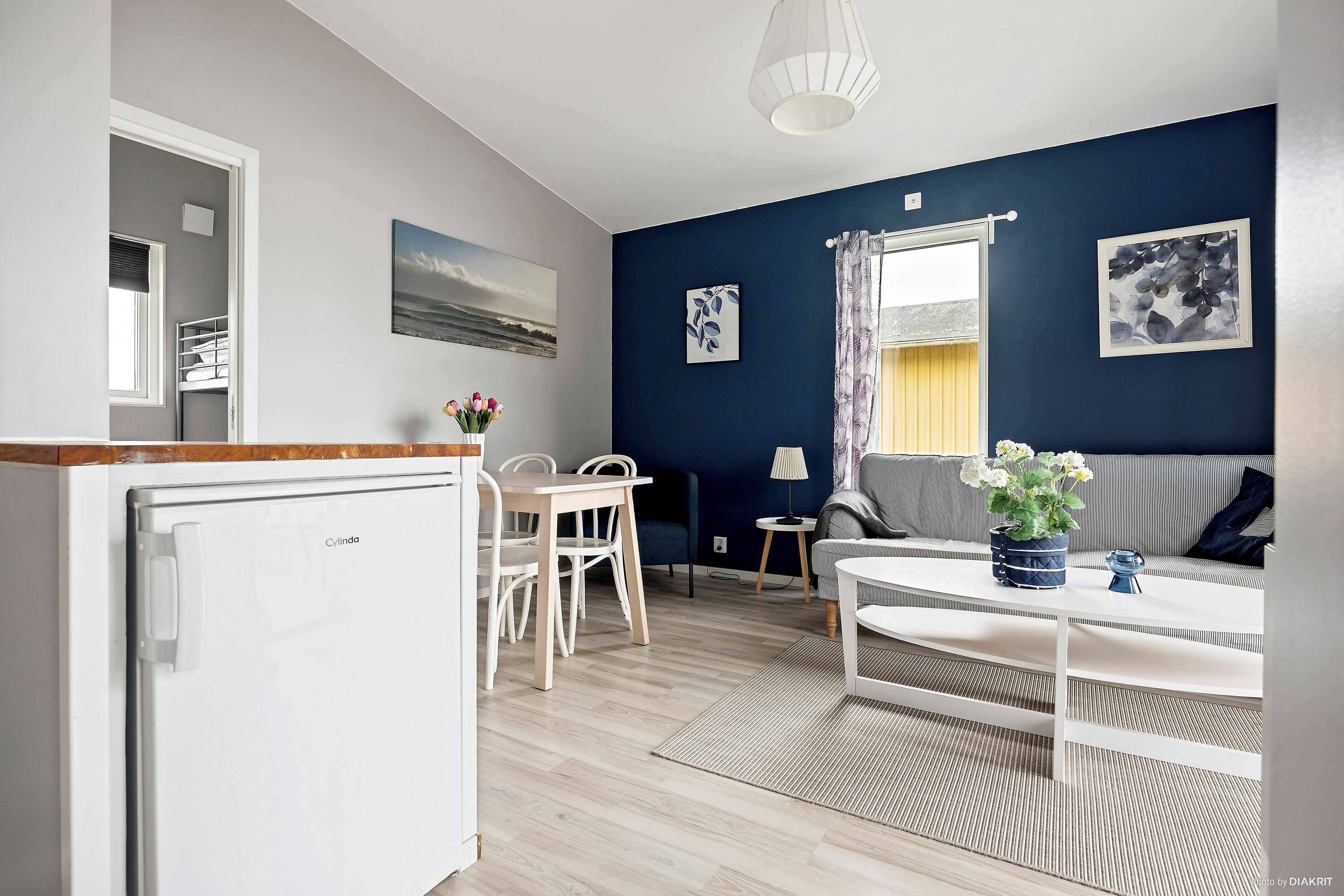 A compact living space with a kitchenette, a dining area, and a seating area with a sofa and table.