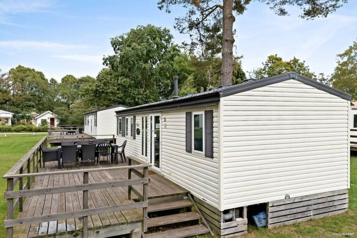 A mobile home with a deck and outdoor seating area.