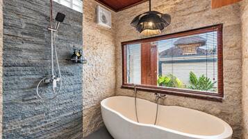 A bathroom with a freestanding bathtub, a shower with a rain showerhead, and a window with blinds.