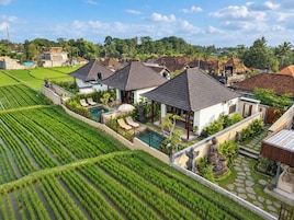 Zona residencial con casas, piscina y campos de cultivo en terrazas.