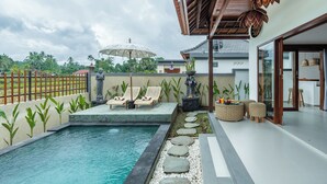 A modern outdoor pool area with lounge chairs, a statue, and a pergola. - Mahayani Ubud Villa (Tegallalang)