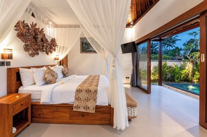 Un dormitorio con una cama grande, televisión y vista a una piscina.