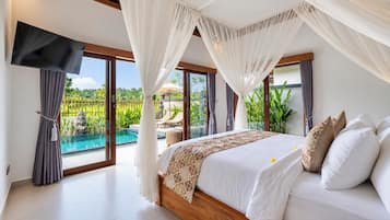 A bedroom with a large bed, a TV, and a view of a swimming pool.