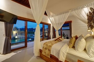 Un dormitorio con una cama grande, vistas a una piscina y un balcón.