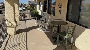 A balcony with a table and chairs, a railing, and a view of the neighborhood. - Charming, very quiet house (Lake Havasu City)