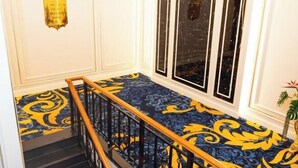 A staircase with a blue and yellow patterned carpet, white walls, and a black railing. - The Premier Palace Hotel and Spa (Phnom Penh)